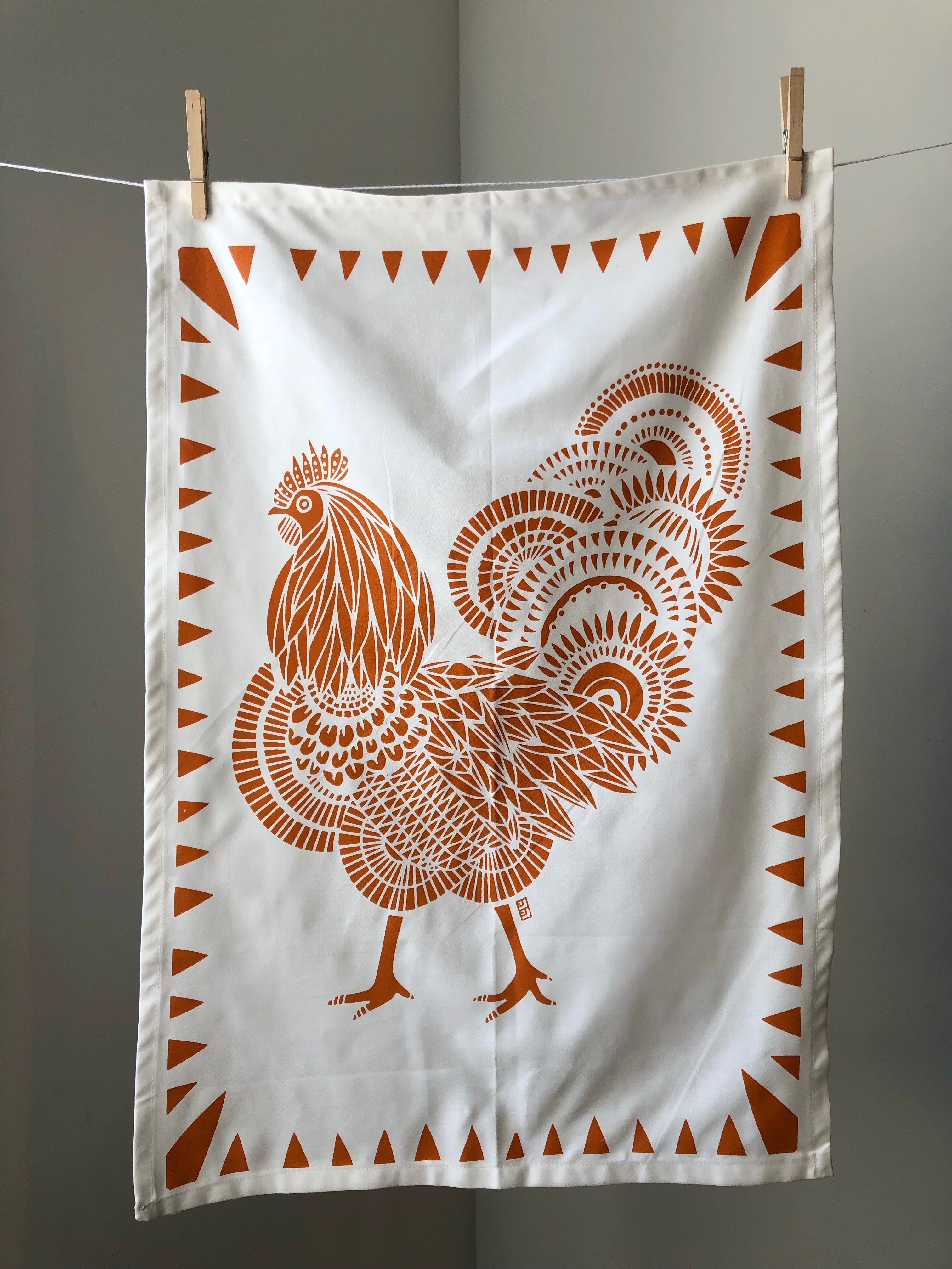 Display of tea towel with rooster print.