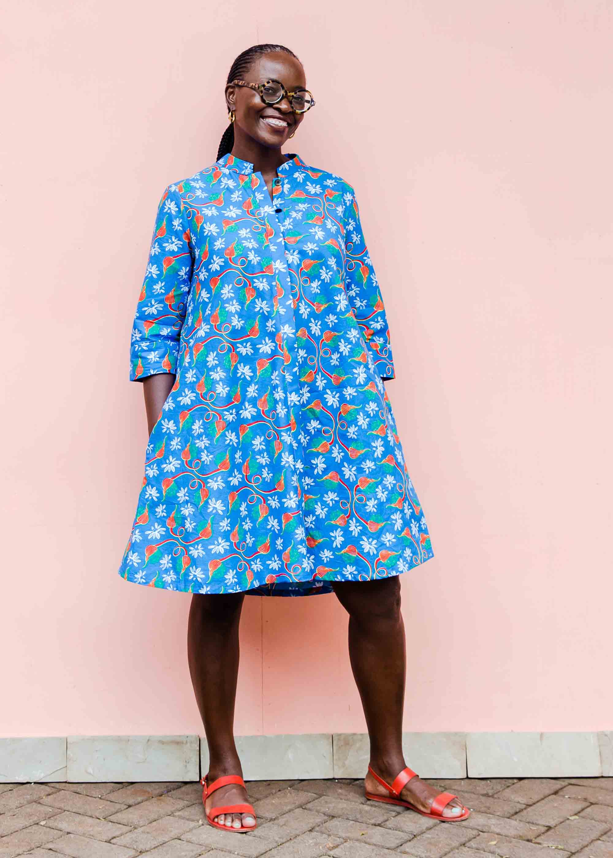 model wearing a blue, red and white flower pod design shirt dress