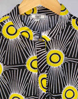 Display of black and white dress with yellow burst print.