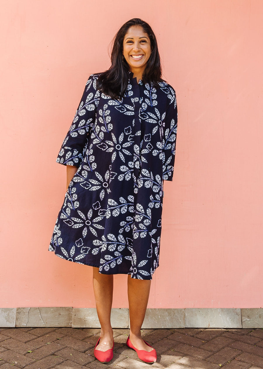 Model wearing navy dress with white floral print.