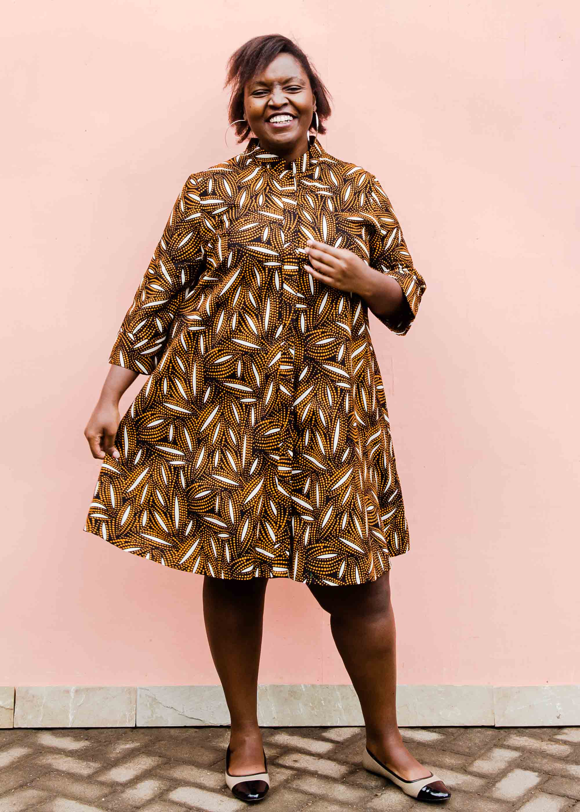 model wearing a brown, black and white seed design dress