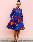 model wearing a rooster and chick design dress in blue, red and orange