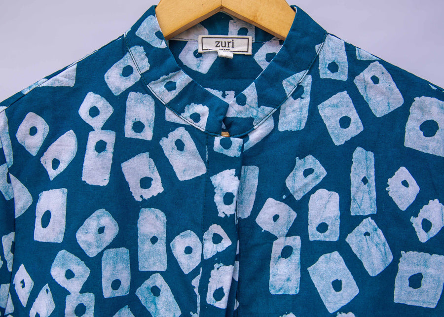 Close up display of blue, white domino print shirt.