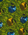 Close up display of green sleeveless dress with blue and yellow bubble design, fabric.