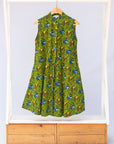Display of green sleeveless dress with blue and yellow bubble design.