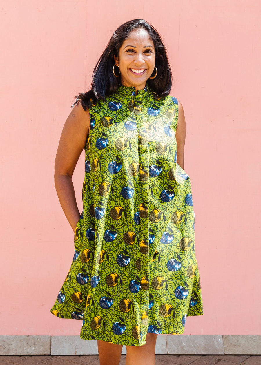 Model wearing green sleeveless dress with blue and yellow bubble design.