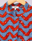 Close up display of blue and red zigzag print blouse.